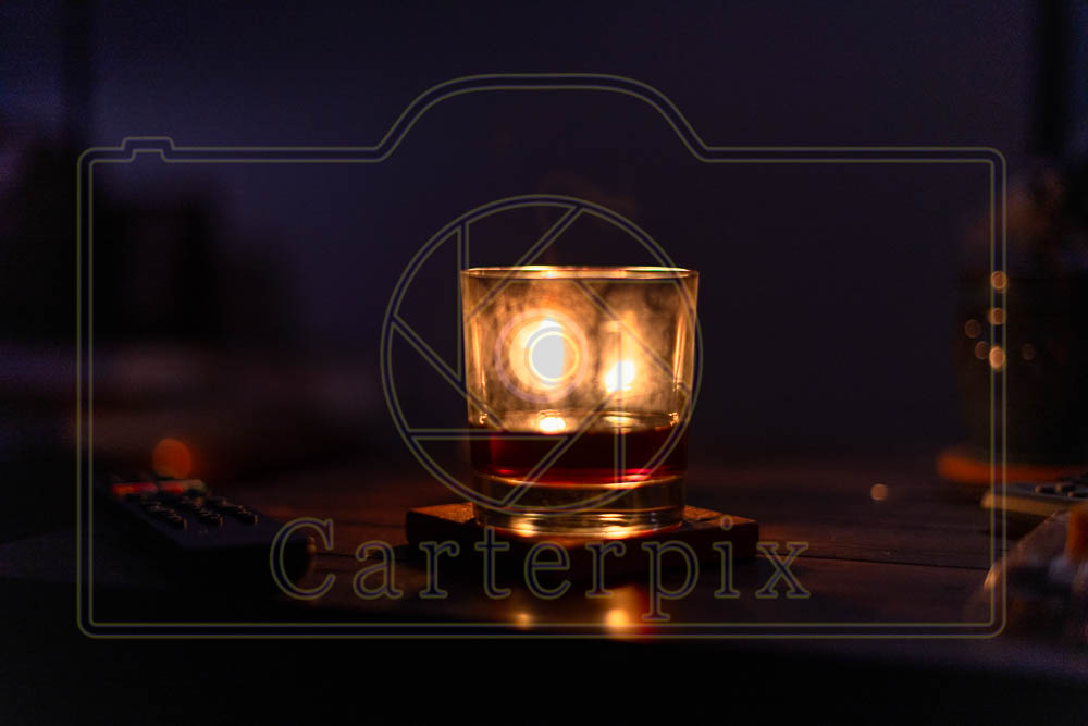 Water marked / Artsy burning candle behind a glass. Dark and moody.