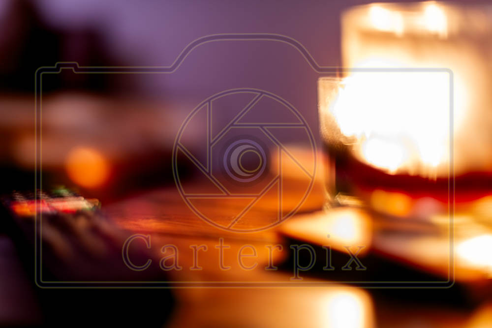 Water marked / artsy burning candle behind a glass.
